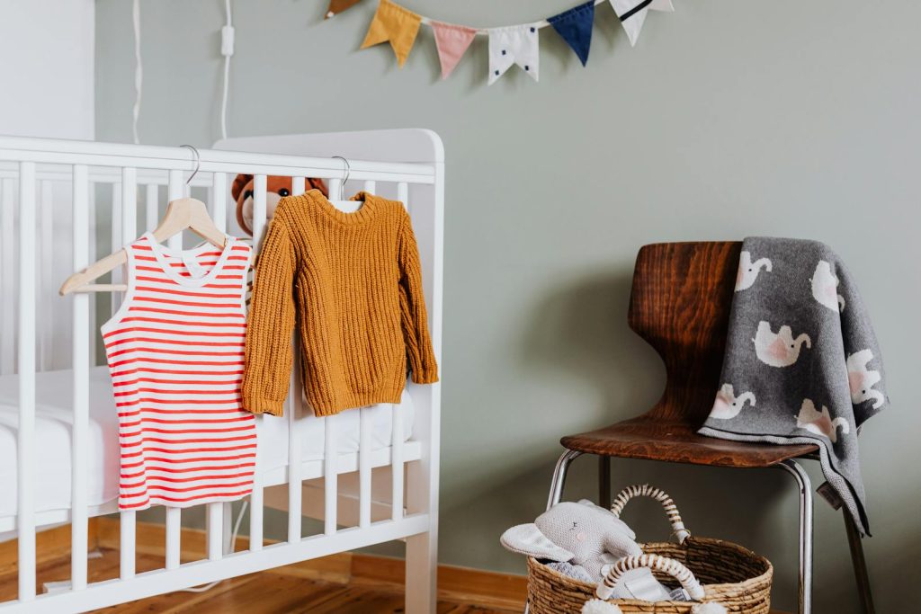 Photo of Baby Clothes Hanging on Crib- Eco-Friendly Baby Products