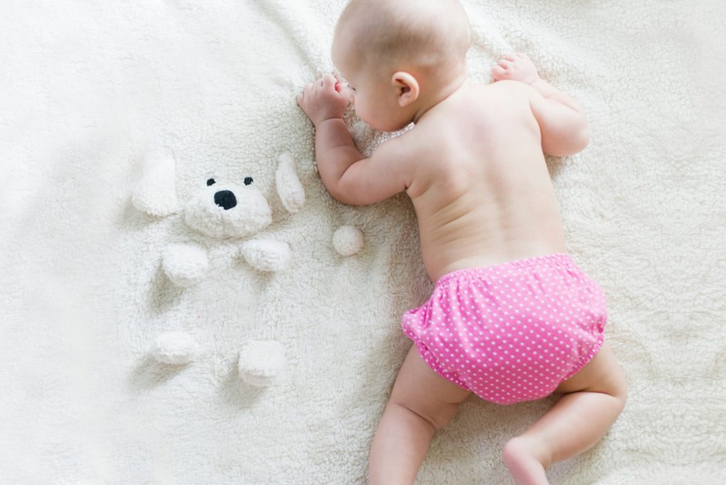 baby crawling on bed - Eco-Friendly Diapers